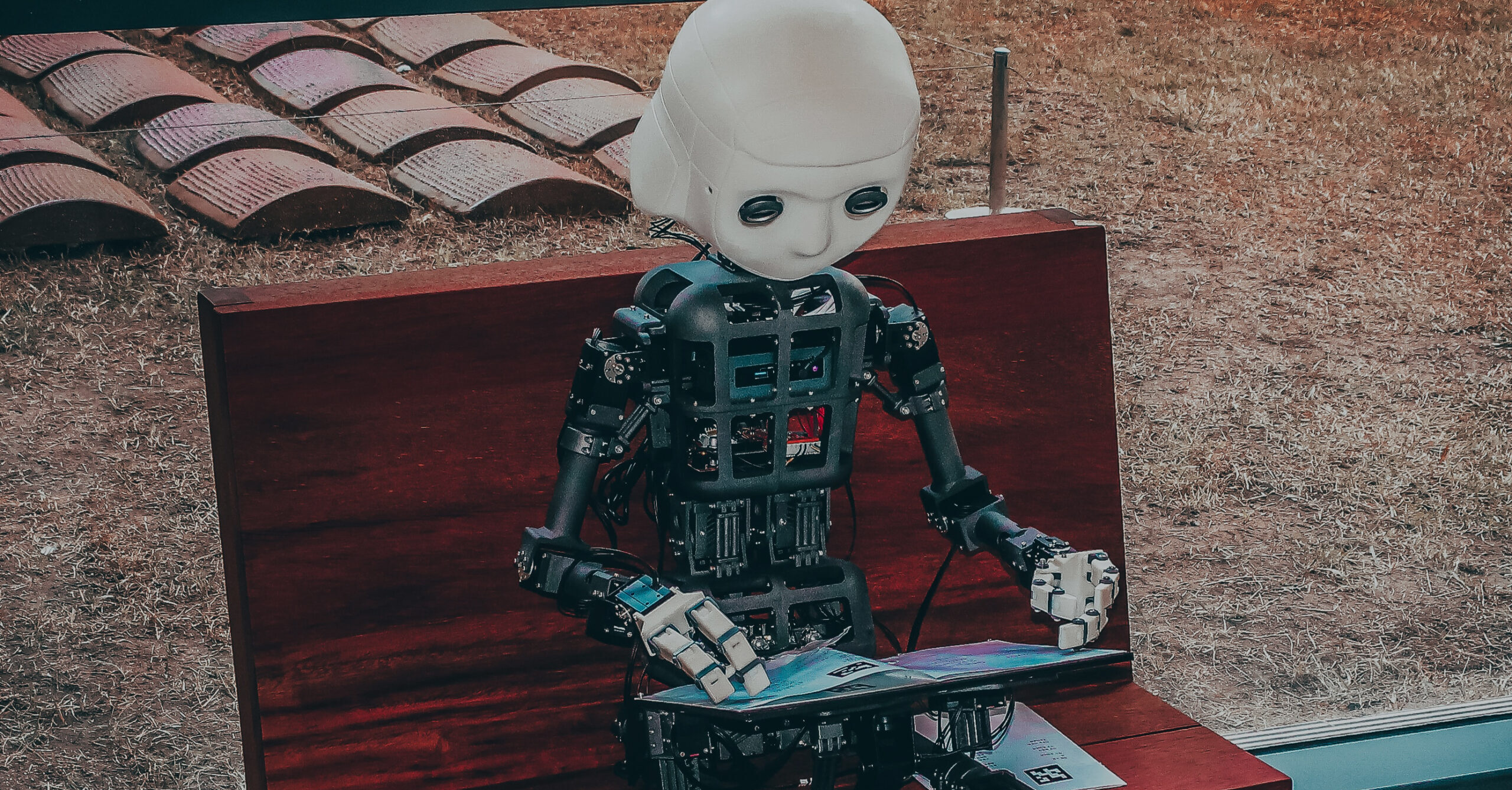 Robot child reading a book on a bench