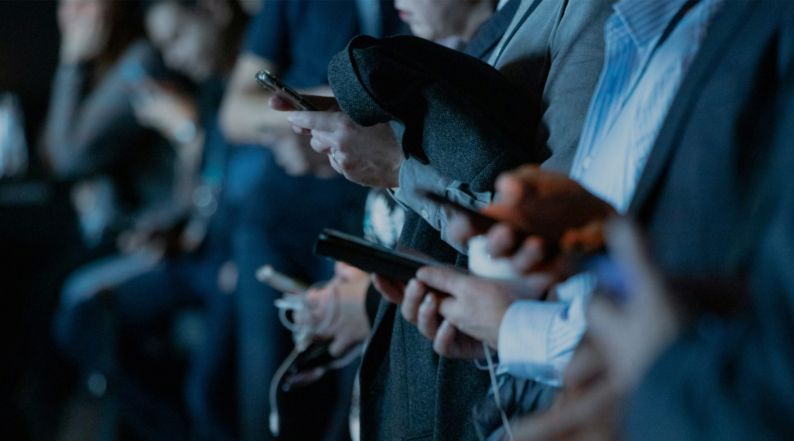 Row of hands holding smartphones